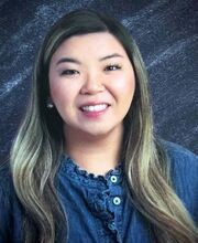 Melissa Cieto smiling with long dark hair with highlights and wearing a blue button up collarless top