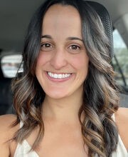 Anabel Graham smiling with long brown hair and wearing a v-neck sleeveless top
