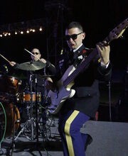 Nick Rice playing bass guitar on stage with the US Army Band