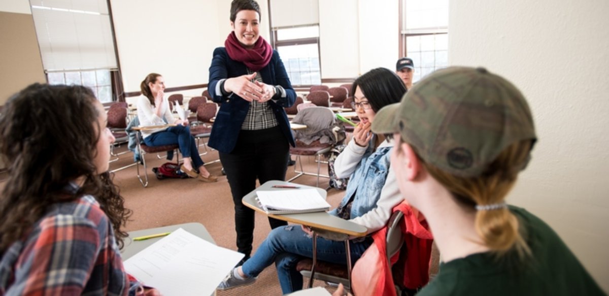 A professor talking to a small group in a class A professor talking to a small group in a class