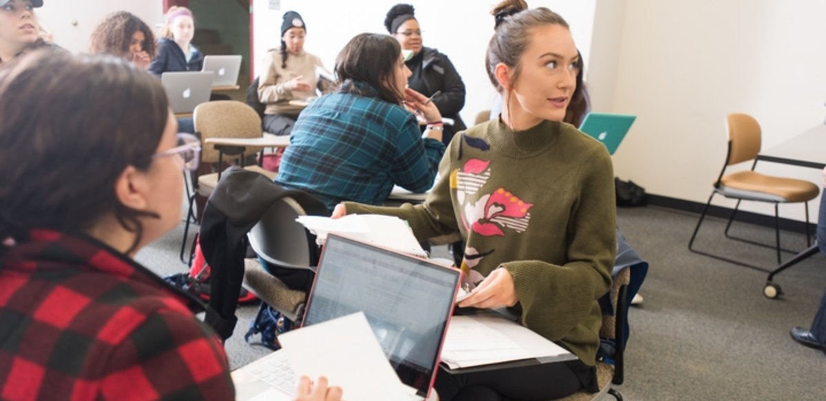 Students working in groups listening to the professor Students working in groups listening to the professor