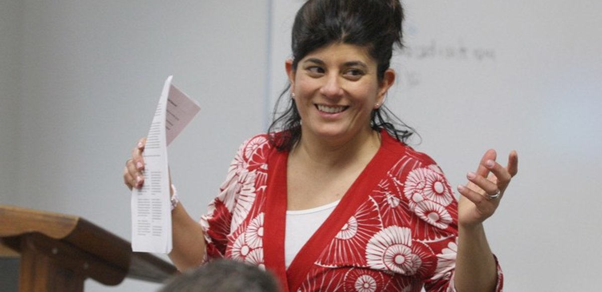 Professor Sarah Thomas teaching a class and smiling Professor Sarah Thomas teaching a class and smiling