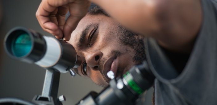 A student looking through a telescope