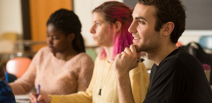 Students listening to professor and taking notes