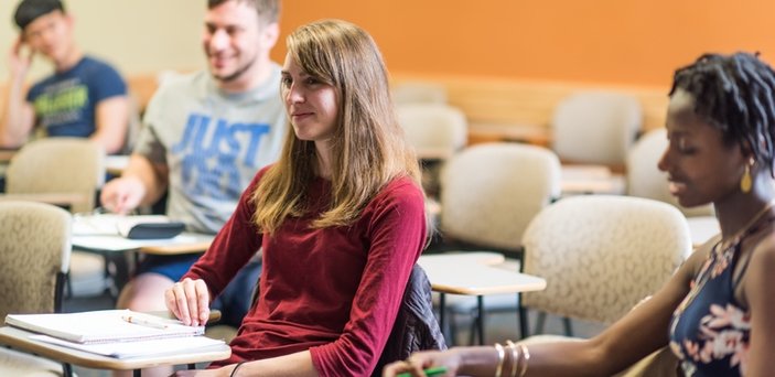 Students in class smiling at the professor