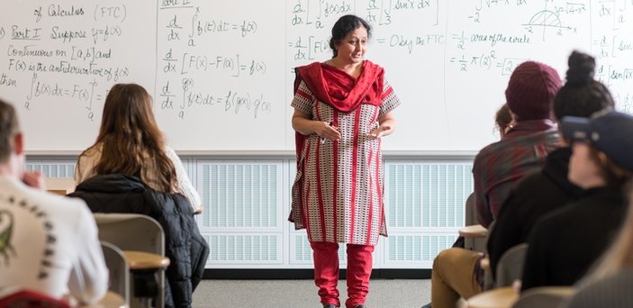 Professor Uma Shama teaching a class standing in front of a white board that outlines the Fundamental Theorem of Calculus