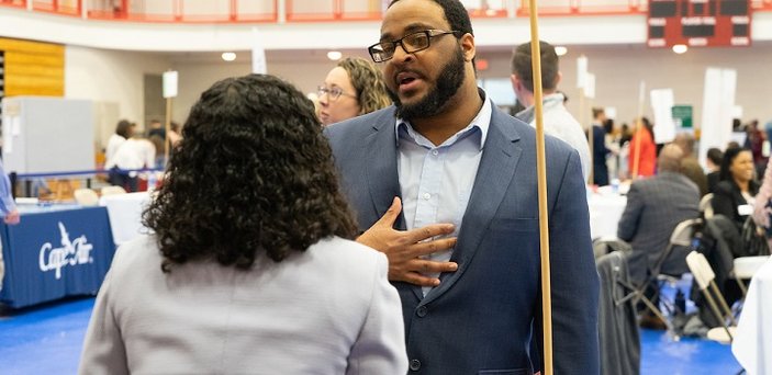 A student meets with an employer at the Job and Internship Fair.