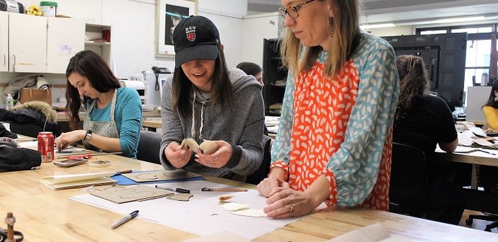 A student works with Professor Leigh Craven in the book arts program. 