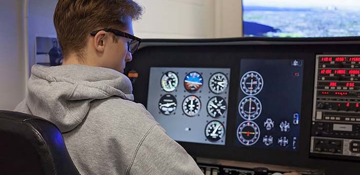 Aviation student operates a flight simulator