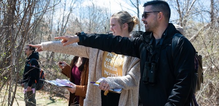 A fire ecology class explores the woods on campus.