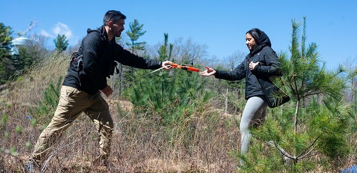 A fire ecology class explores the woods on campus.