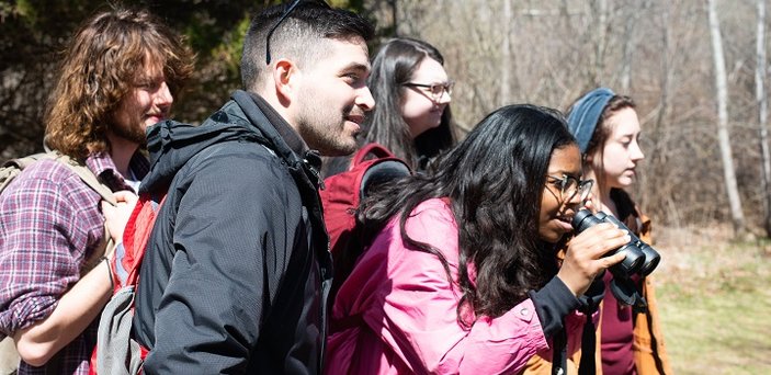 A fire ecology class explores the woods on campus.