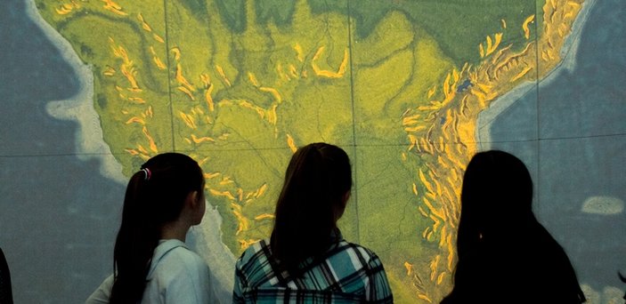 Three students viewing the inside of the EarthView globe