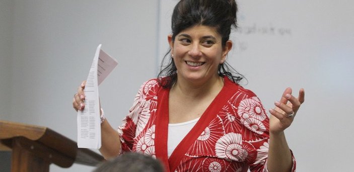 Professor Sarah Thomas teaching a class and smiling