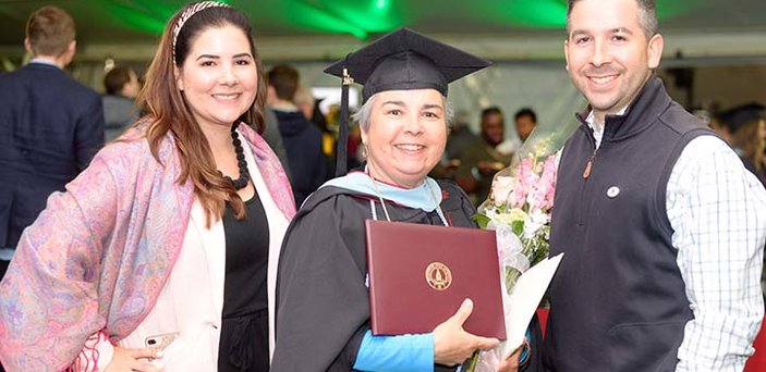 A graduate celebrates with family