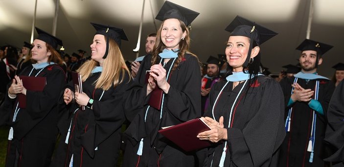 Graduates applaud.