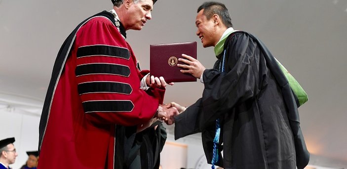 President Clark hands out a diploma.