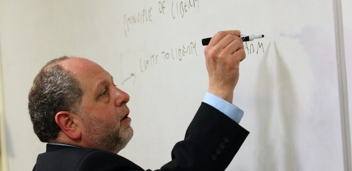 Professor Aeon Skoble writing on a white board in class about the principle of liberty