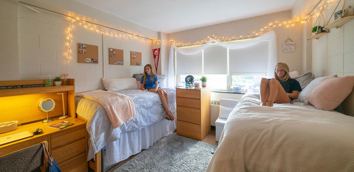 Two students study on their beds