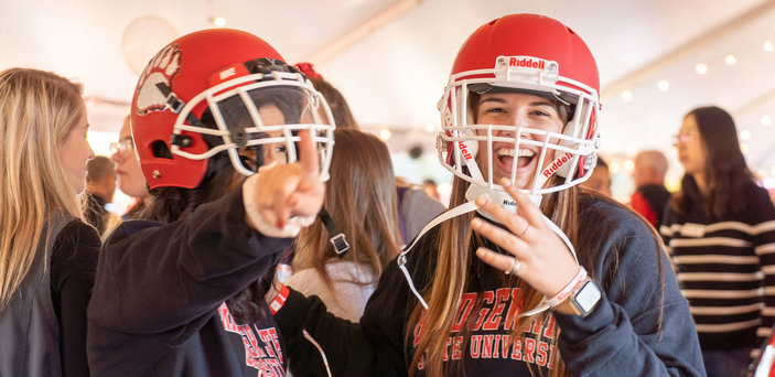 students try on football helmets