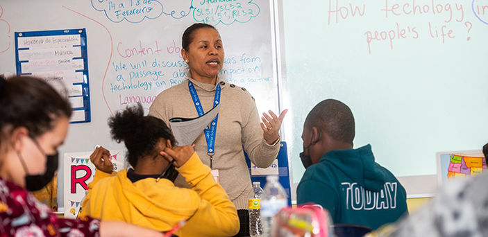 BSU student teacher teaching in front of white boards with notes written in English and Spanish