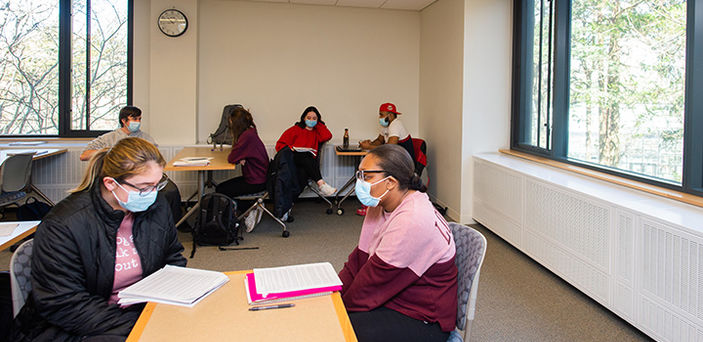 3 pairs of students work together at tables reading and discussing in Allyson Ferrante's seminar