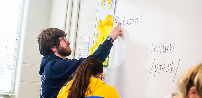students writing on a white board in Phonetics class