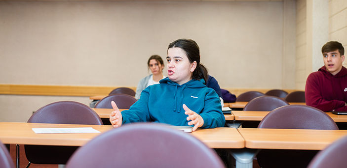 a student speaking in class while other students look on
