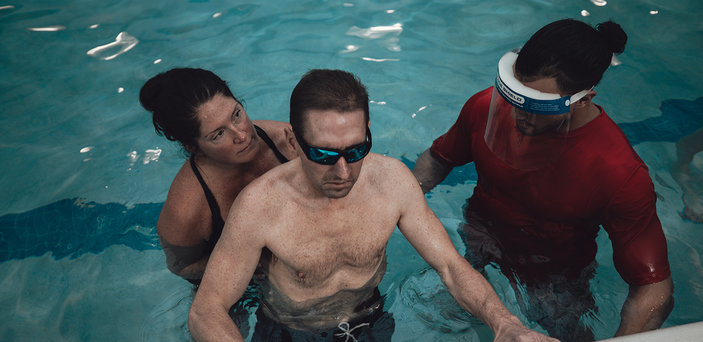A BSU student works in the pool with a Parkinson's patient.