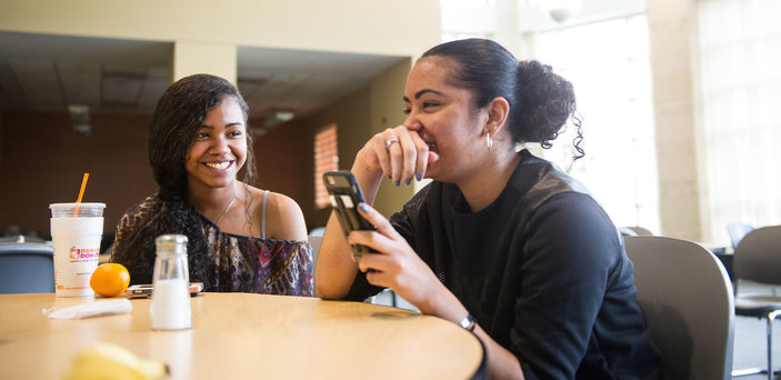 Friends laugh with each other during lunch