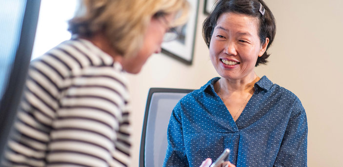 Visiting scholar Huifang Zhao (right) talks with Jeanne Kling, ’79.