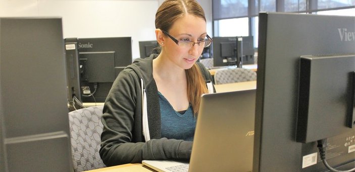 Student working on her laptop in computer lab