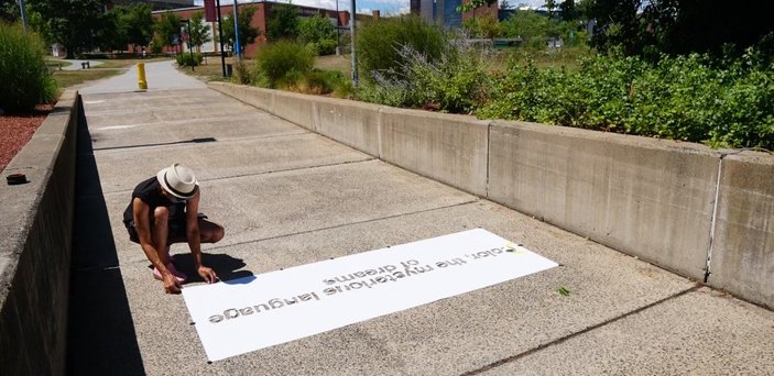 Free Humanity paints quote on sidewalk