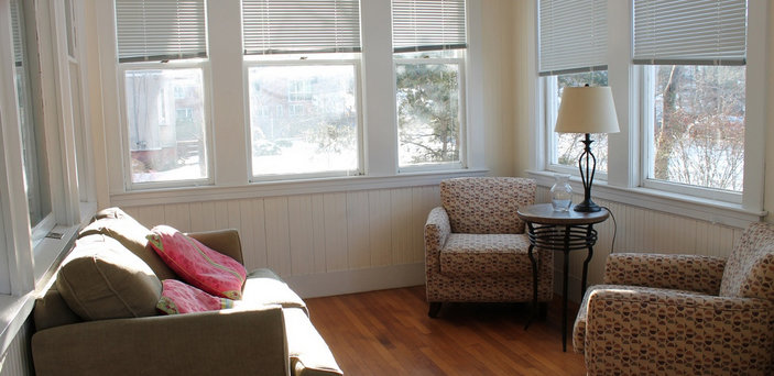 Scholar House sitting room with loveseat, 2 chairs and a lamp