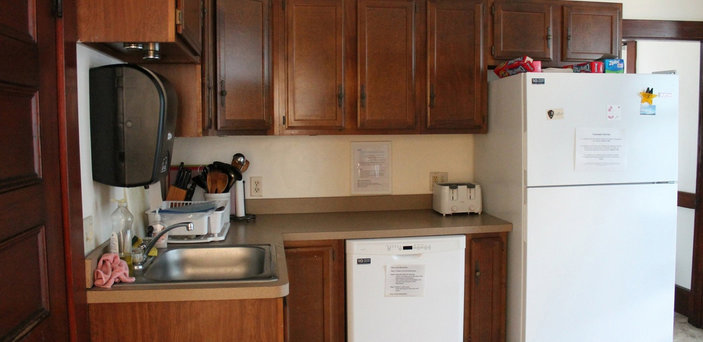 Scholar House kitchen showing refrigerator, dishwasher, toaster, sink, cabinets and counter top