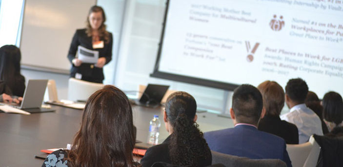 BSU students sitting at a conference room table watching a presentation during an outing to Price Waterhouse Cooper