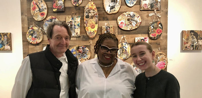 Jay Block, Lavett Ballard and Elizabeth Ezekiel stand in the art gallery with Ballard's work behind them.