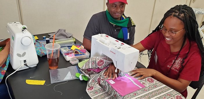 A fellow sews a dress.