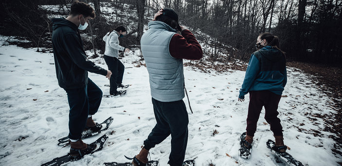 Students snowshoe on campus trails.