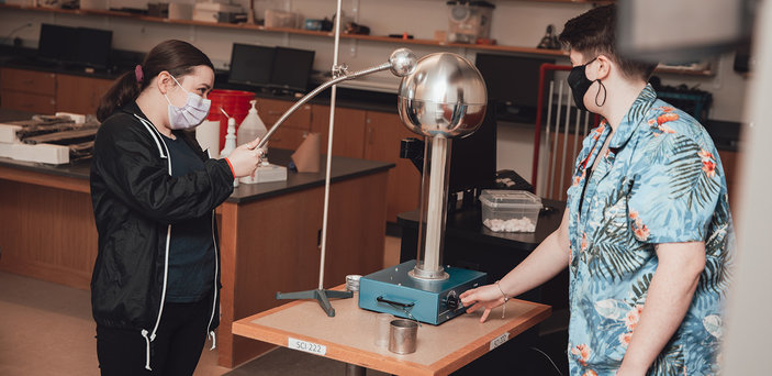 Students demonstrate a Van de Graaff generator.