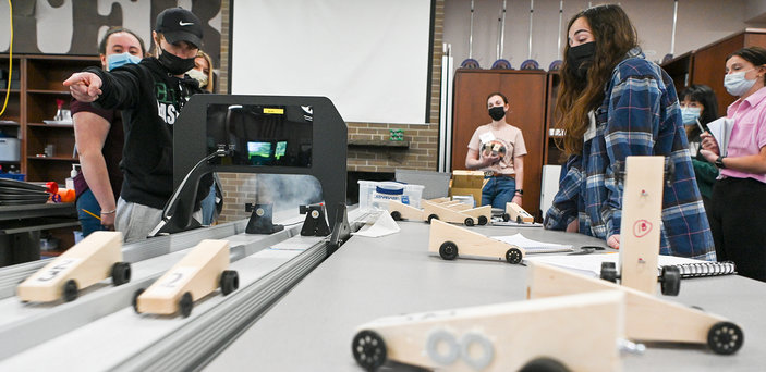 Mini wooden racing cars  used in a STEM activity are displayed on a table.