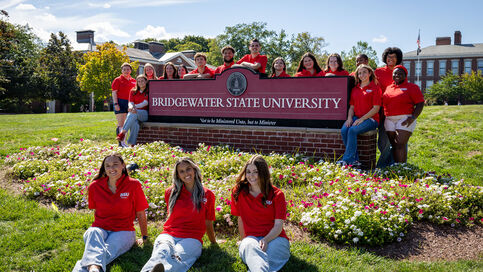 BSU student tour guides around the BSU sign on Boyden Quad