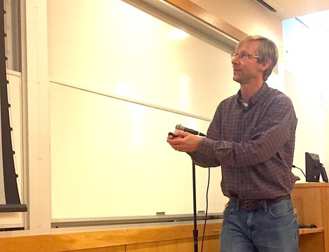 Dr. Rob Hellström points to a slide projected on a screen du Dr. Rob Hellström points to a slide projected on a screen du
