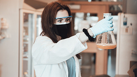 Ashlyn Grace Kelly holds a beaker while working in a lab.