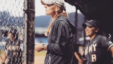 Brianna Strecker, '13 stands in dugout