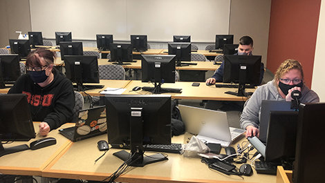 Students work at computers on a cybersecurity competition.