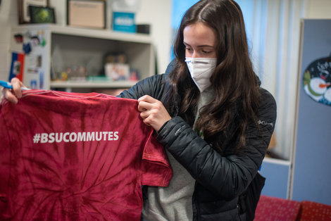 Student holding t shirt with #BSUCommutes written on it
