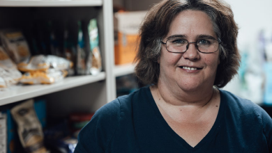 Dawn Maden, '22 poses inside of BSU Food pantry shelves