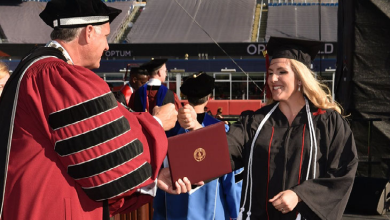 President Fred Clark fist pumps Georgia Johnson, '21 at commencement
