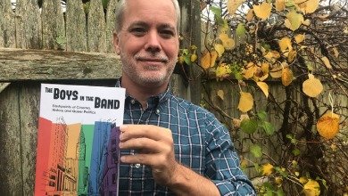 Professor Matt Bell holds up book he edited and contributed to
